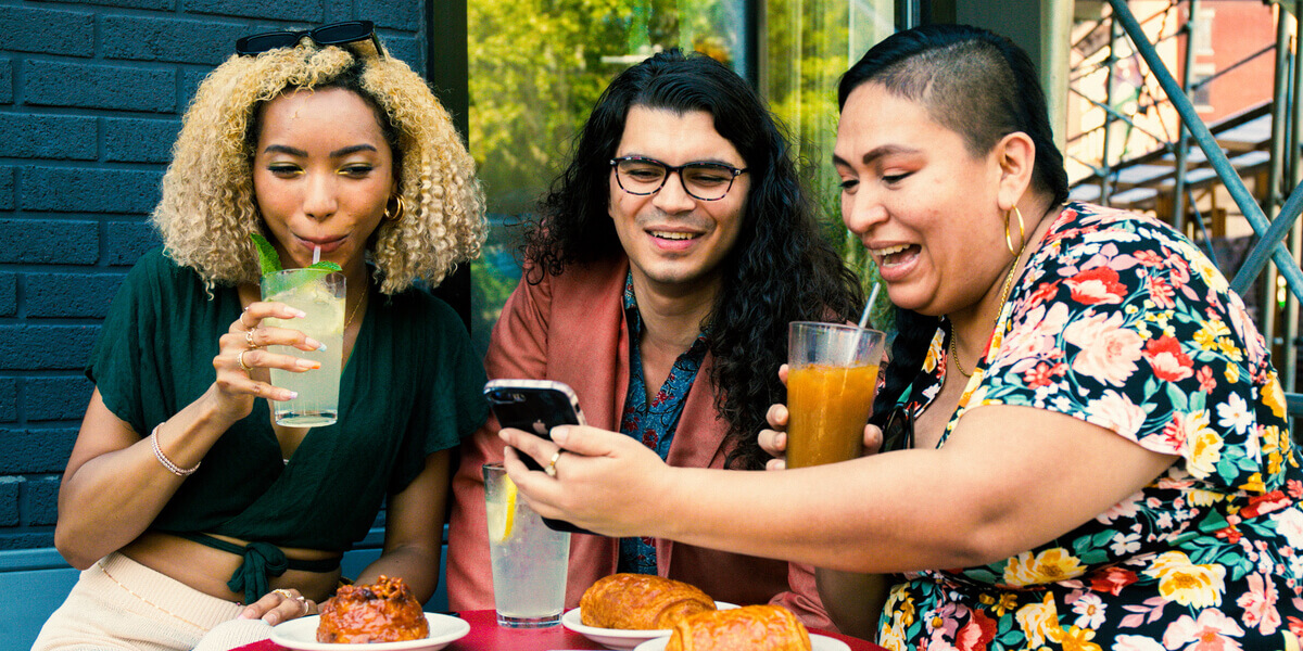 Three people laughing and enjoying coffee