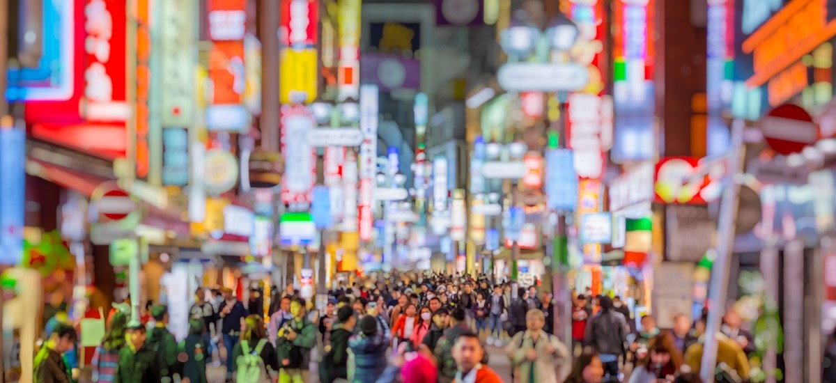 Blurred, crowded, bright Tokyo street lit up at night